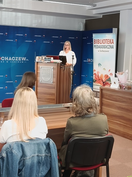 Kobieta wygłasza prezentację do publiczności.